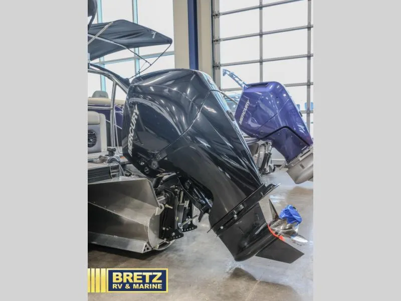 Slide: The Image of 2023 Cabrio 24UC boat with dual Mercury outboard motors in showroom. - 6