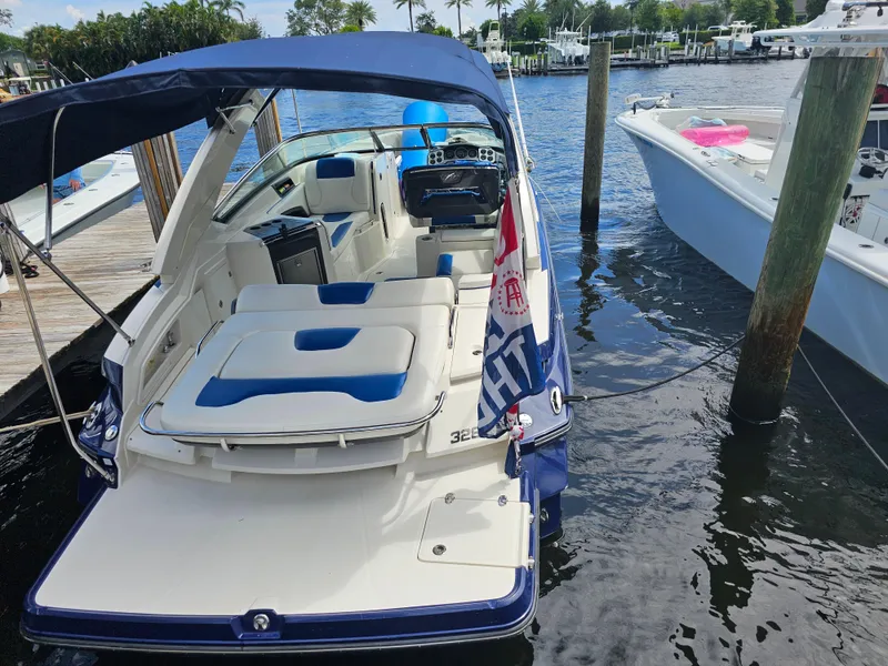 Slide: The Image of 2012 Monterey 328SS Super Sport boat docked at marina, featuring spacious seating and canopy. - 8
