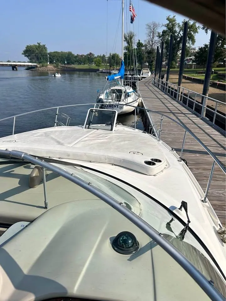 Slide: The Image of 2003 Sea Ray 320 Sundancer docked by a scenic waterfront. - 10