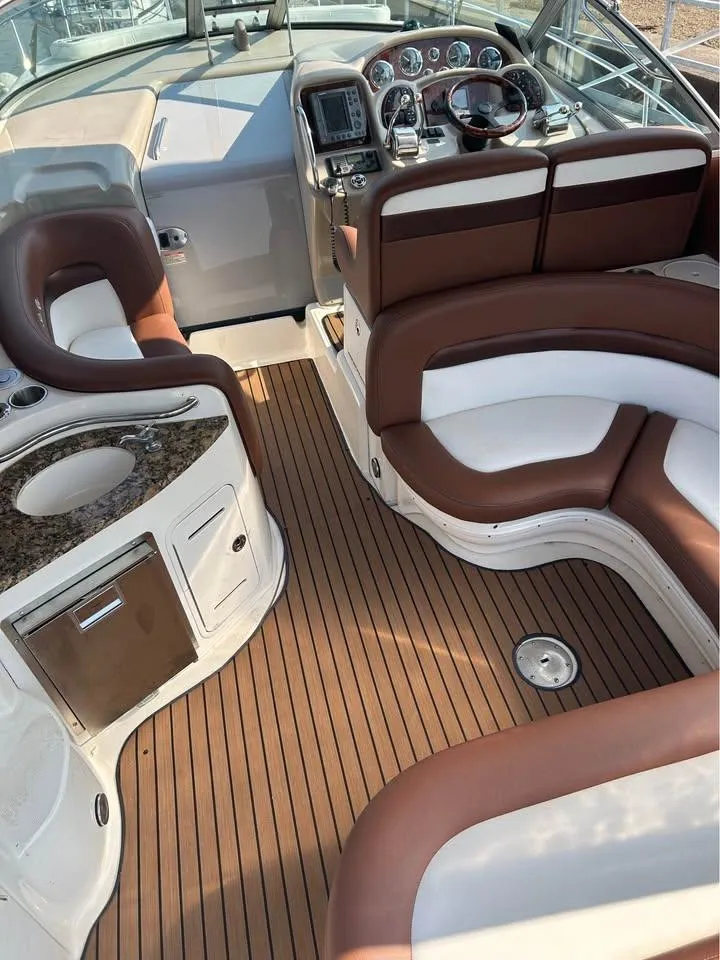 Slide: The Image of 2003 Sea Ray 320 Sundancer interior with plush seating and modern dashboard. - 11
