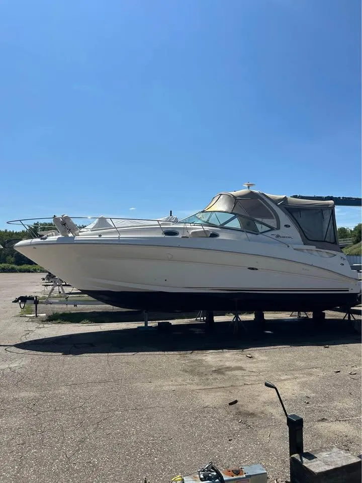 Slide: The Image of 2003 Sea Ray 320 Sundancer boat on dry dock under clear blue sky. - 12