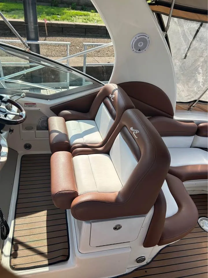 Slide: The Image of 2003 Sea Ray 320 Sundancer cockpit with brown and white seating, showcasing luxury design. - 13