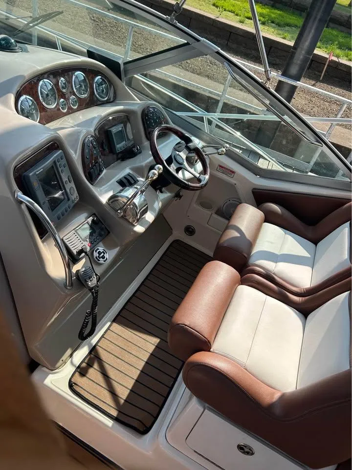 Slide: The Image of 2003 Sea Ray 320 Sundancer cockpit with dual seats and modern navigation controls. - 15