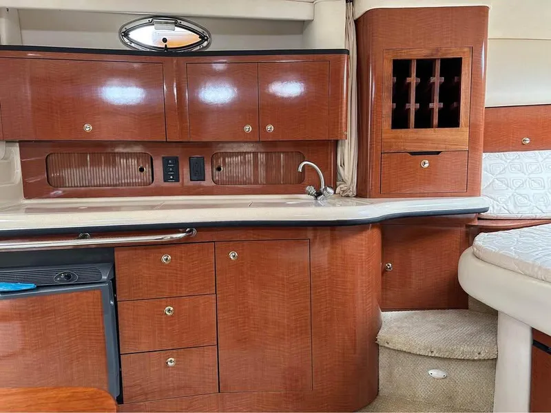 Slide: The Image of Interior of 2003 Sea Ray 320 Sundancer yacht with wooden cabinetry and compact kitchen area. - 19