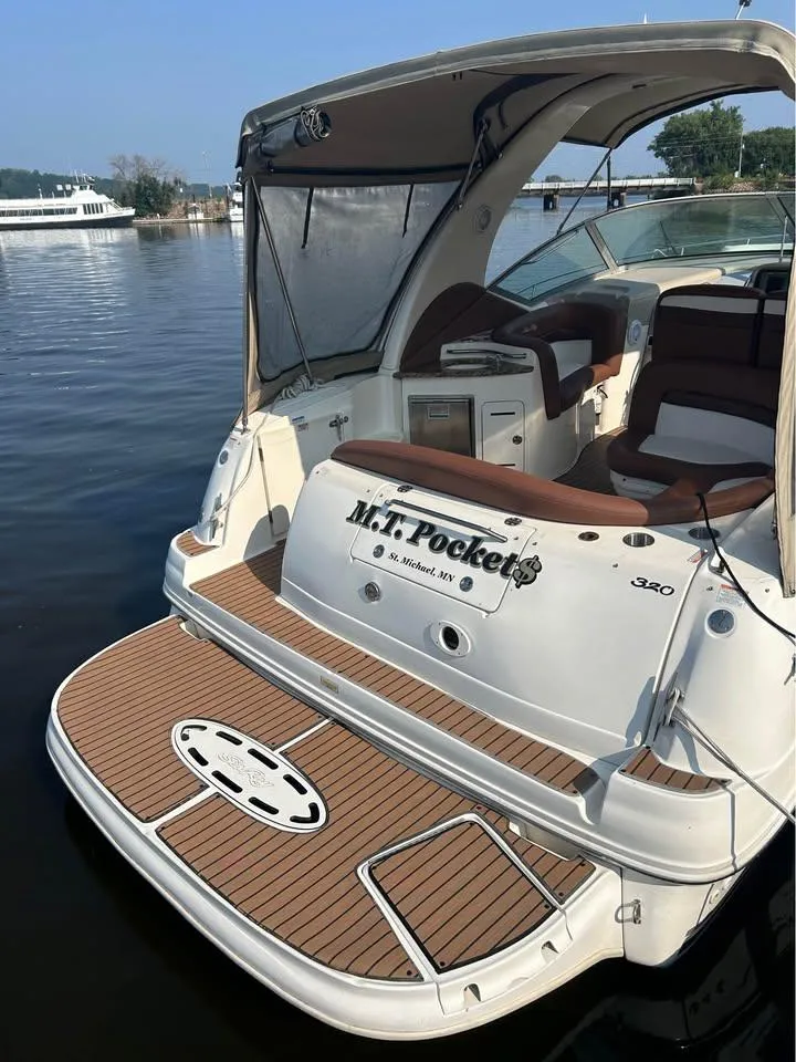 Slide: The Image of 2003 Sea Ray 320 Sundancer boat docked on calm water. - 2