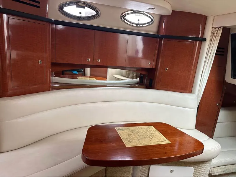 Slide: The Image of Interior of 2003 Sea Ray 320 Sundancer with wood table and white seating. - 4