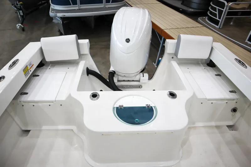 Slide: The Image of 2025 Parker 2120 Sport Cabin boat interior with motor and seating. - 8