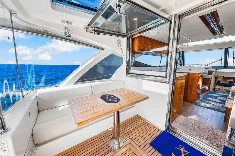 Slide: The Image of 2022 Riviera 505 SUV interior with ocean view, featuring a wooden table and seating area. - 40