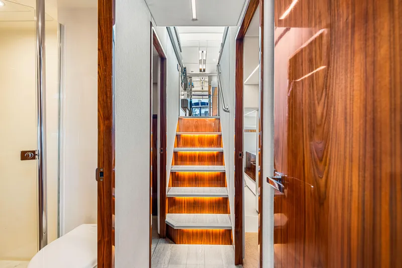 Slide: The Image of Interior of 2022 Riviera 505 SUV yacht with illuminated wooden stairs and modern design. - 22