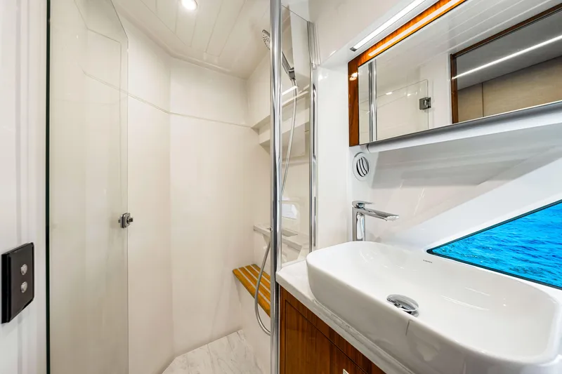 Slide: The Image of Luxurious bathroom interior of 2022 Riviera 505 SUV yacht, featuring modern sink and shower. - 16