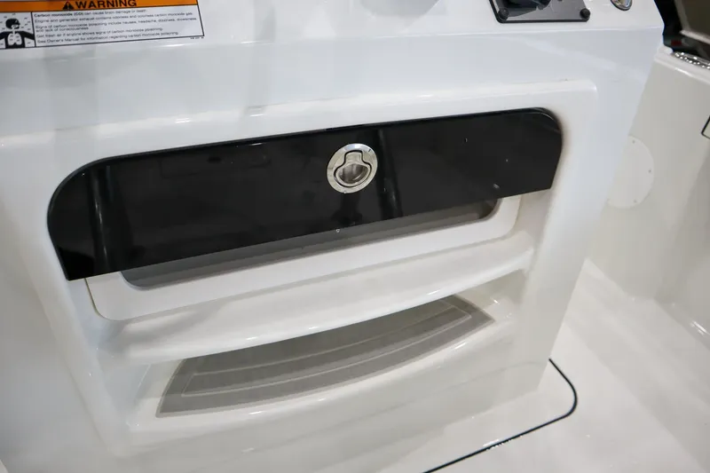 Slide: The Image of 2025 Parker 18SE Center Console boat storage compartment with lock, featuring sleek white and black design. - 13