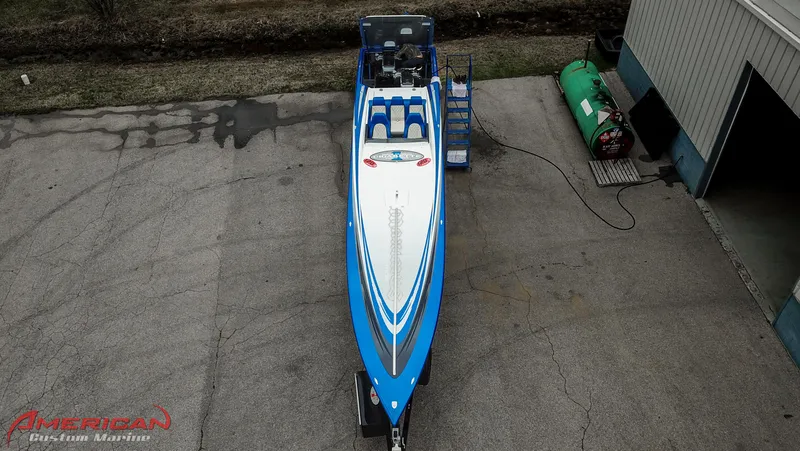 Slide: The Image of 2005 Cigarette 45 Maximus speedboat in blue, parked outside a garage. - 17