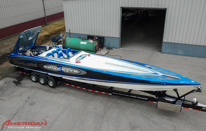 Slide: The Image of 2005 Cigarette 45 Maximus speedboat on trailer, blue and white design, parked outside a building. - 18