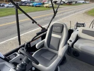 Slide: The Image of 2024 Barletta C22UC boat interior with gray captain's chair and steering wheel. - 9