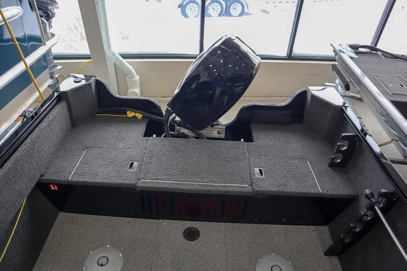 Slide: The Image of 2025 Crestliner 1650 KODIAK WT boat interior with motor, gray carpeted deck. - 4