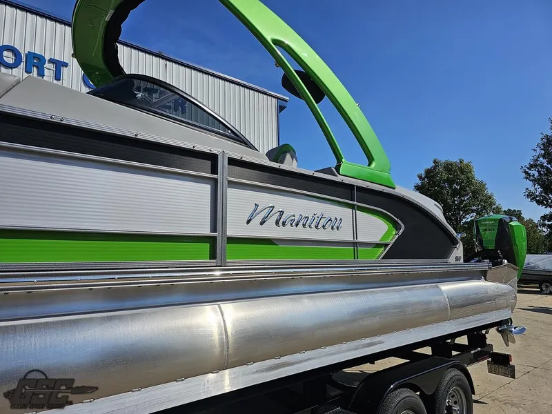 Slide: The Image of 2021 Manitou 25 X-Plode pontoon boat with green accents on a trailer. - 11