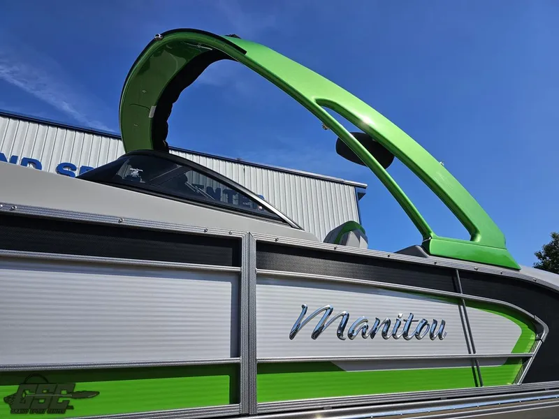 Slide: The Image of 2021 Manitou 25 X-Plode pontoon boat with green accents under a clear blue sky. - 12