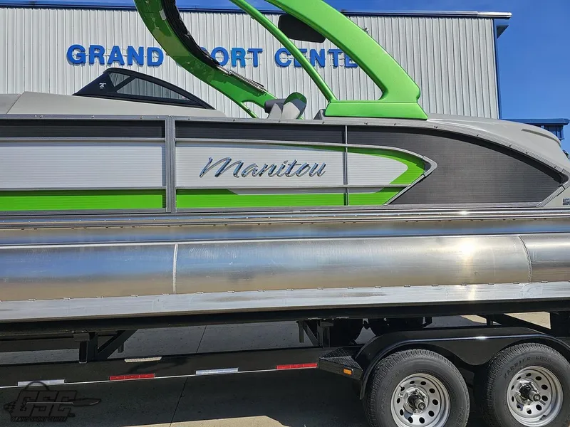 Slide: The Image of 2021 Manitou 25 X-Plode pontoon boat with green accents on a trailer. - 16