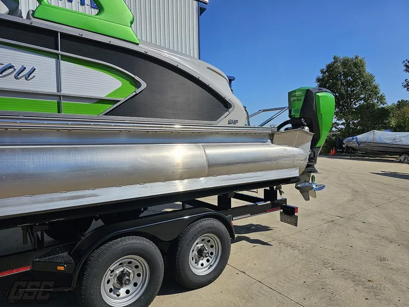 Slide: The Image of 2021 Manitou 25 X-Plode pontoon boat on trailer, featuring green and silver design. - 17