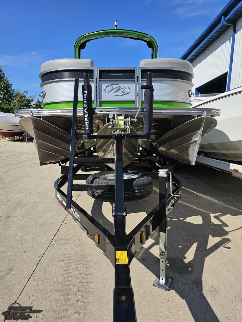 Slide: The Image of 2021 Manitou 25 X-Plode pontoon boat on trailer, outdoor setting. - 20
