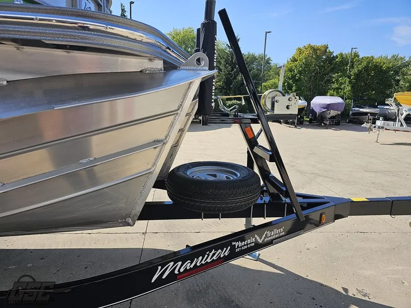 Slide: The Image of 2021 Manitou 25 X-Plode boat on trailer, parked outdoors on a sunny day. - 24