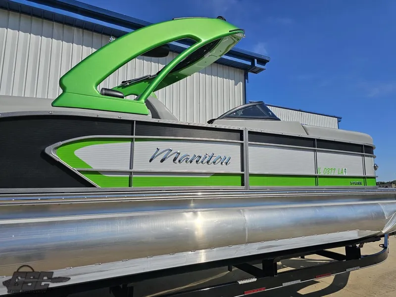 Slide: The Image of 2021 Manitou 25 X-Plode pontoon boat with green accents, docked outdoors. - 26