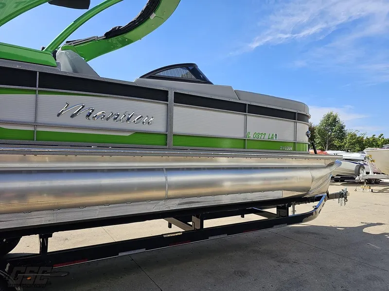 Slide: The Image of 2021 Manitou 25 X-Plode pontoon boat with green accents on a trailer. - 29