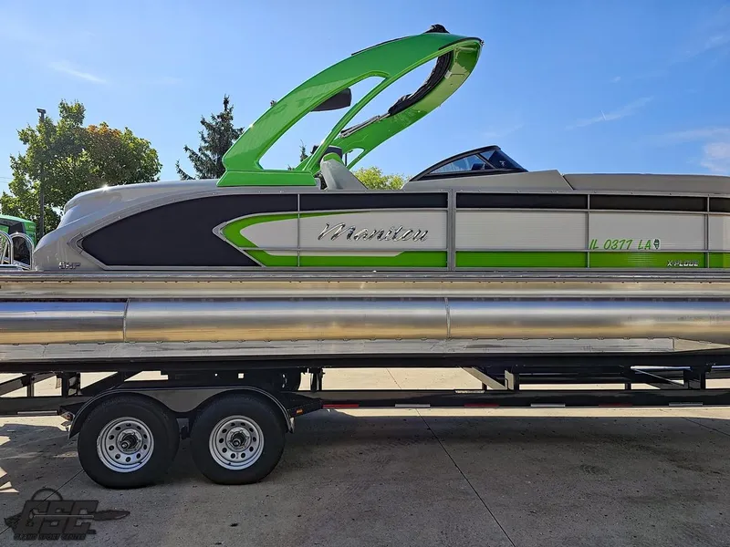 Slide: The Image of 2021 Manitou 25 X-Plode pontoon boat on trailer, featuring green and silver design. - 31