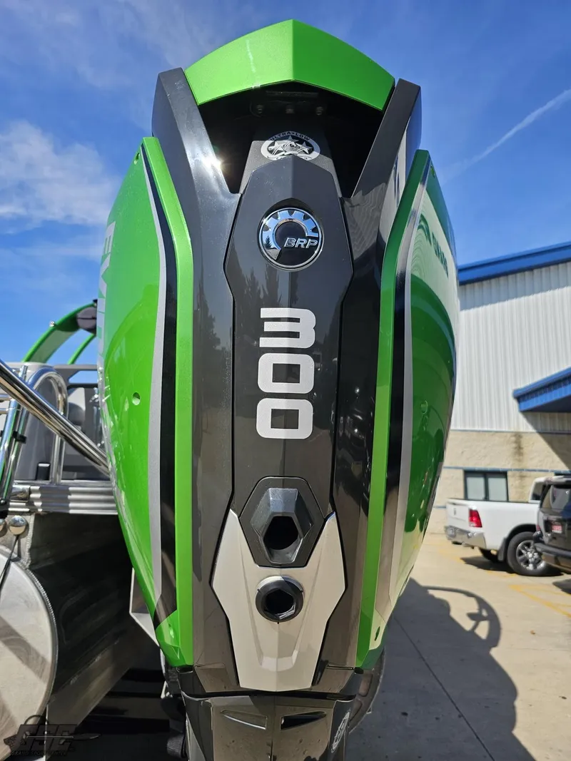 Slide: The Image of 2021 Manitou 25 X-Plode with green BRP 300 outboard motor, parked outdoors. - 39