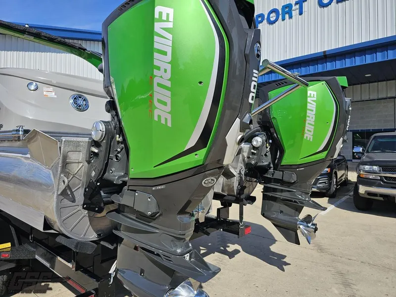 Slide: The Image of 2021 Manitou 25 X-Plode with green Evinrude outboard motors at a dealership. - 43