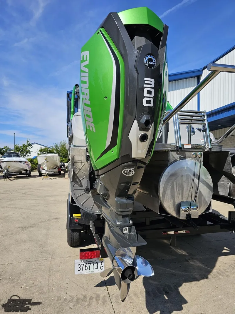 Slide: The Image of 2021 Manitou 25 X-Plode with Evinrude outboard motor, parked outdoors. - 45