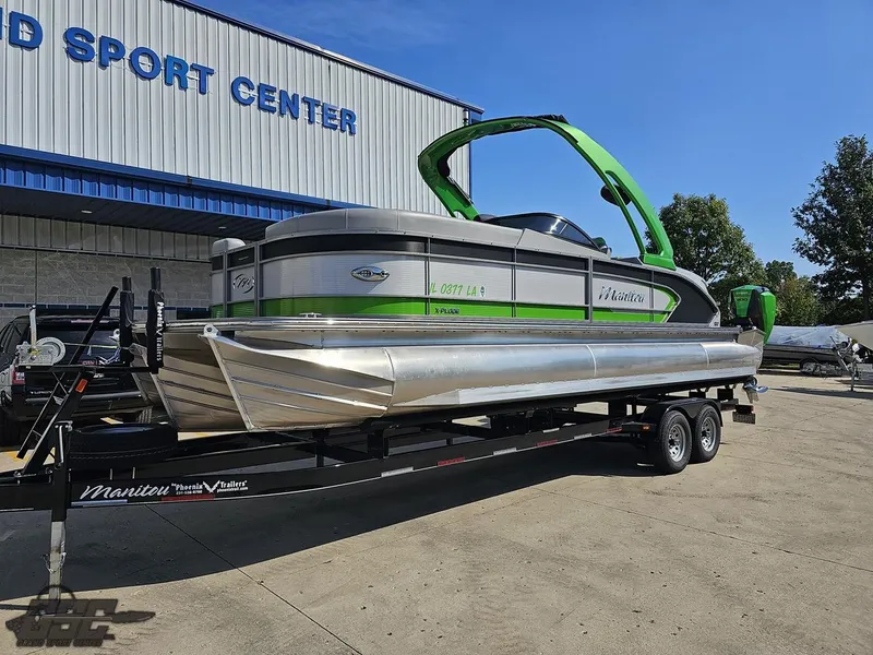 Slide: The Image of 2021 Manitou 25 X-Plode pontoon boat on trailer outside sports center. - 6
