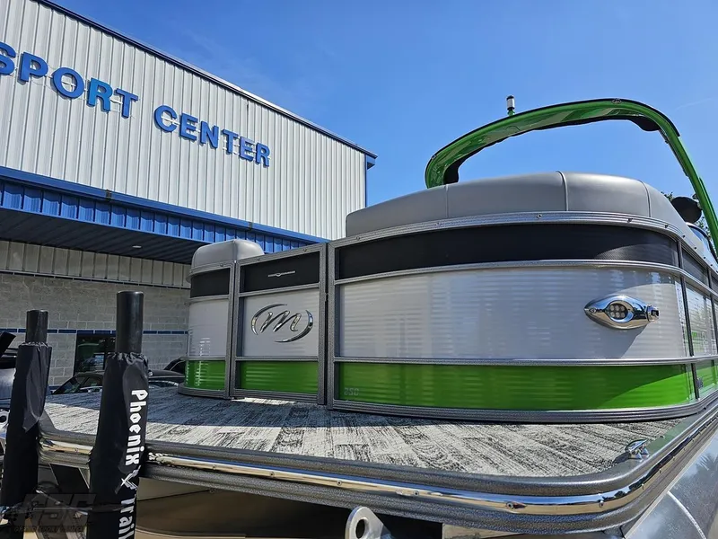 Slide: The Image of 2021 Manitou 25 X-Plode pontoon boat at a sport center, featuring green accents. - 9