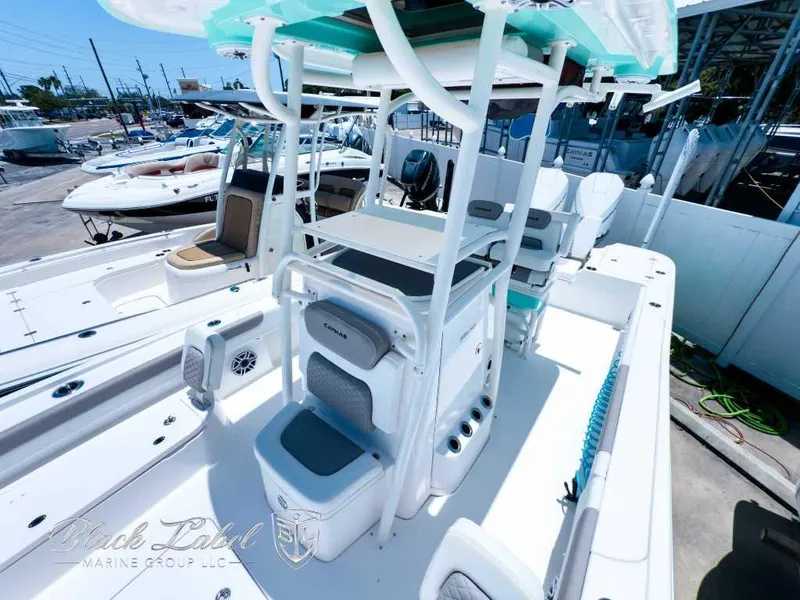 Slide: The Image of 2024 Caymas 281 HB boat interior with seating and console, docked at a marina. - 15