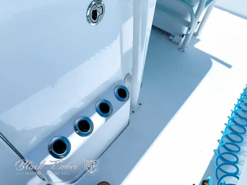 Slide: The Image of 2024 Caymas 281 HB boat deck with rod holders and coiled blue hose. - 18