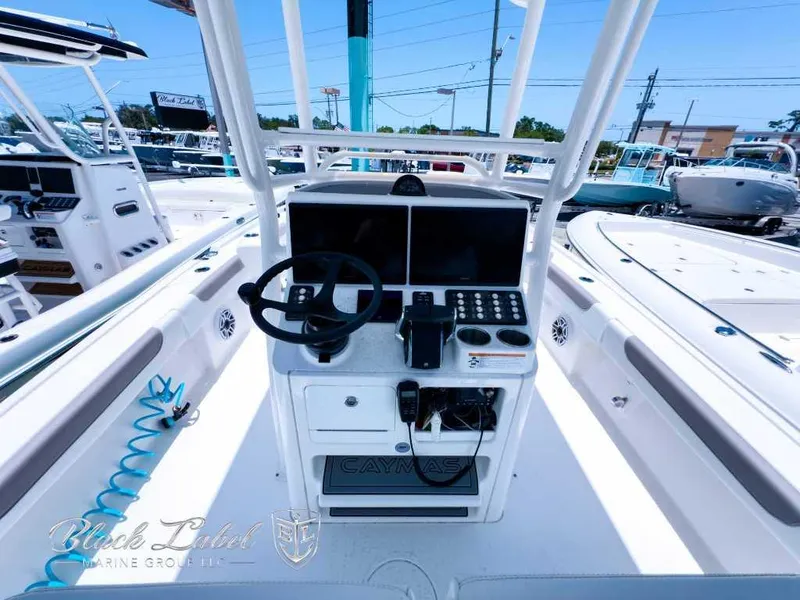 Slide: The Image of 2024 Caymas 281 HB boat console with steering wheel and controls, docked at marina. - 22