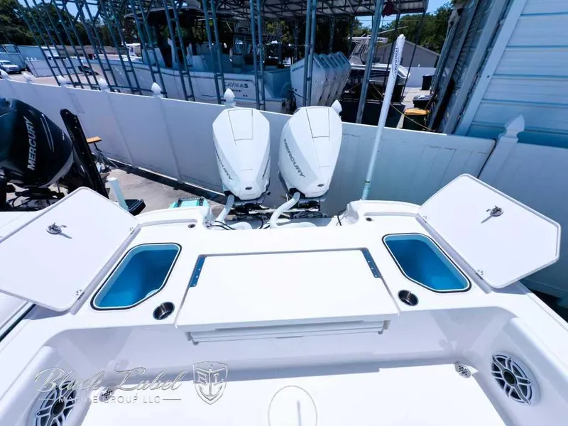 Slide: The Image of 2024 Caymas 281 HB boat with dual outboard engines and open storage compartments. - 23