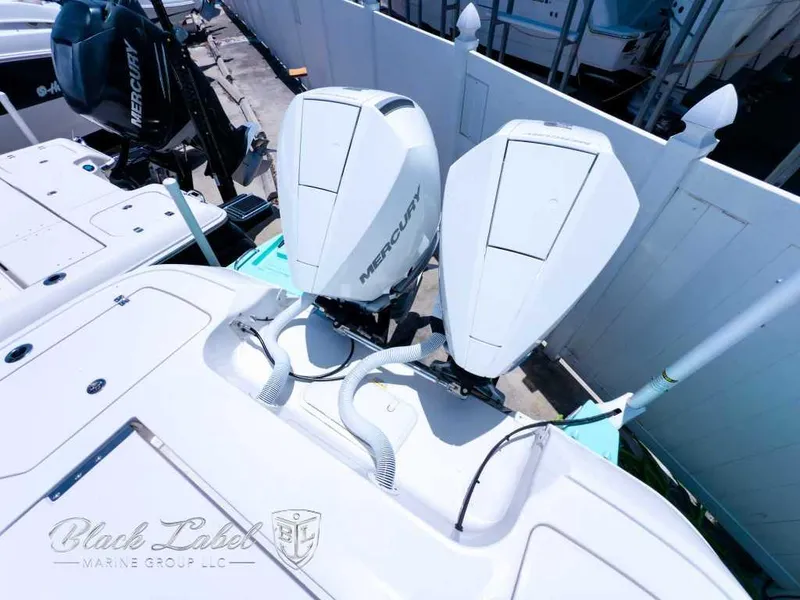 Slide: The Image of 2024 Caymas 281 HB boat with dual Mercury outboard engines, docked at a marina. - 24