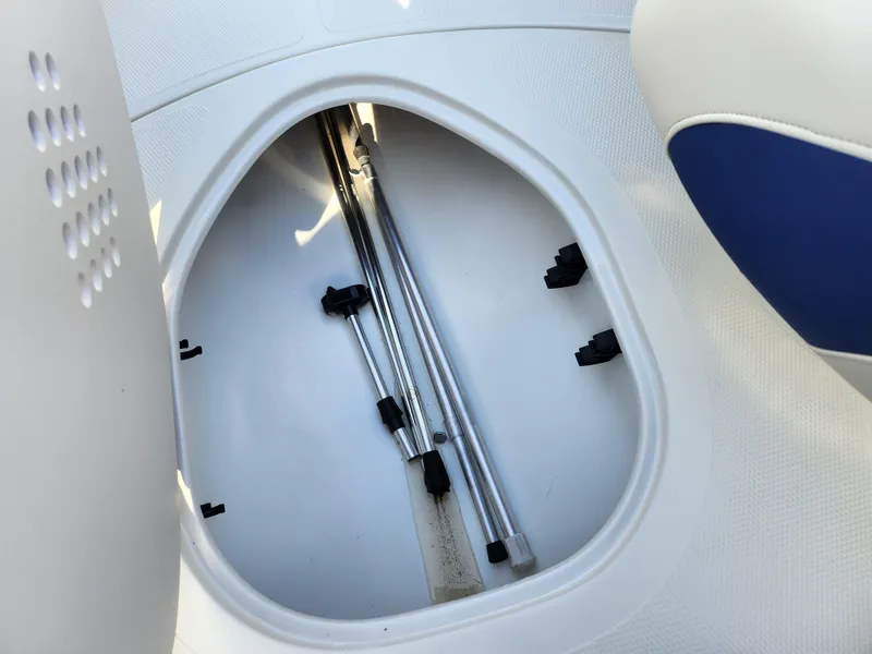 Slide: The Image of Storage compartment in a 2014 Tahoe Q5i SF boat, featuring metal poles and white interior. - 13