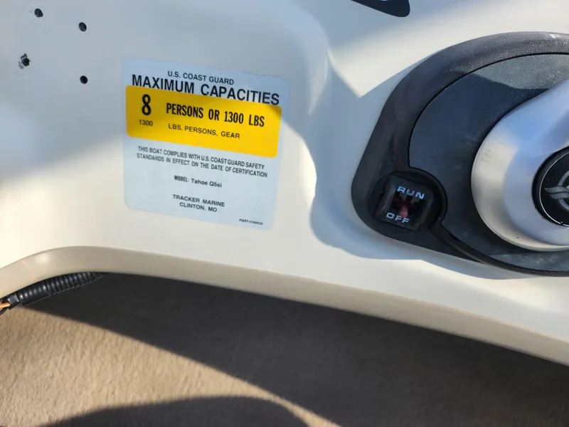 Slide: The Image of 2014 Tahoe Q5i SF boat capacity label, max 8 persons or 1300 lbs, with ignition switch. - 14