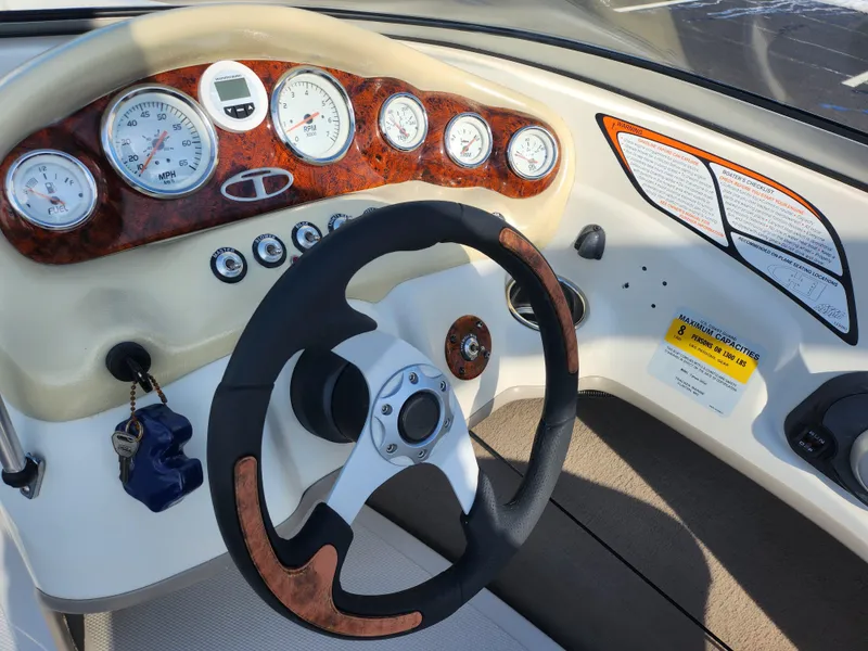 Slide: The Image of Steering wheel and dashboard of 2014 Tahoe Q5i SF boat, featuring gauges and controls. - 15