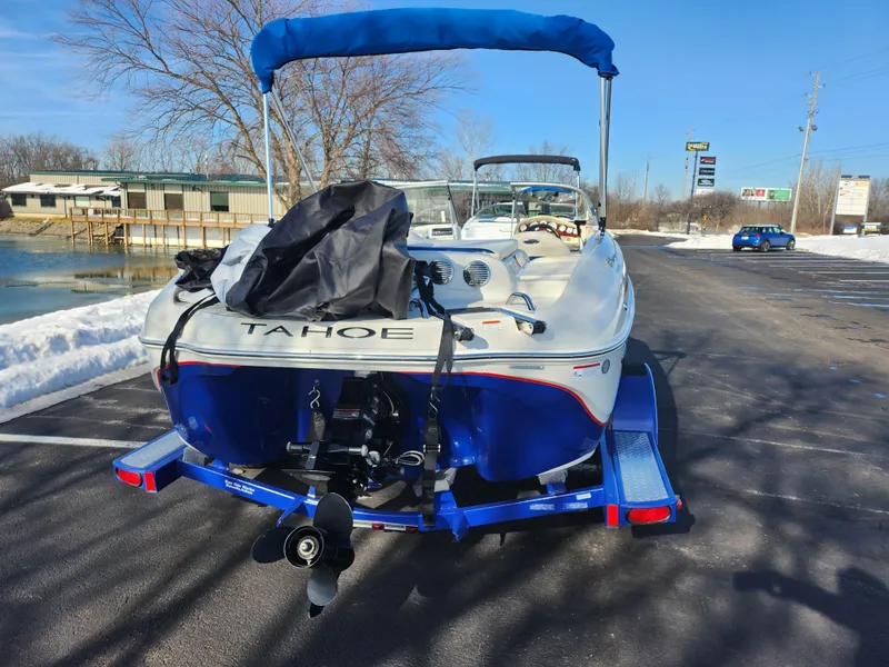 Slide: The Image of 2014 Tahoe Q5i SF boat on trailer, parked near snowy lakeside. - 2
