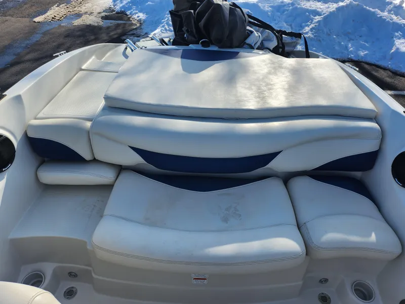 Slide: The Image of 2014 Tahoe Q5i SF boat interior with white cushioned seating and storage compartments. - 21