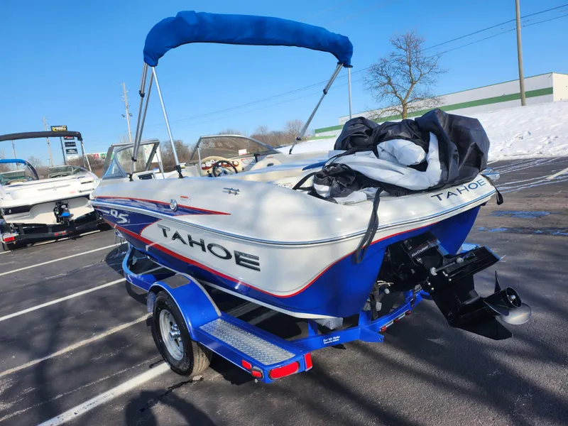 Slide: The Image of 2014 Tahoe Q5i SF boat with blue trailer in a parking lot. - 3