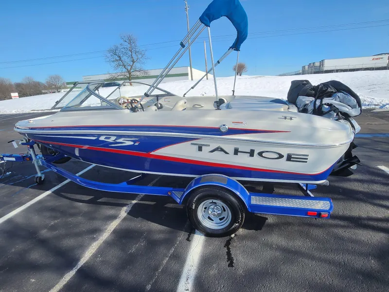 Slide: The Image of 2014 Tahoe Q5i SF boat on trailer, parked outdoors on a sunny day. - 4