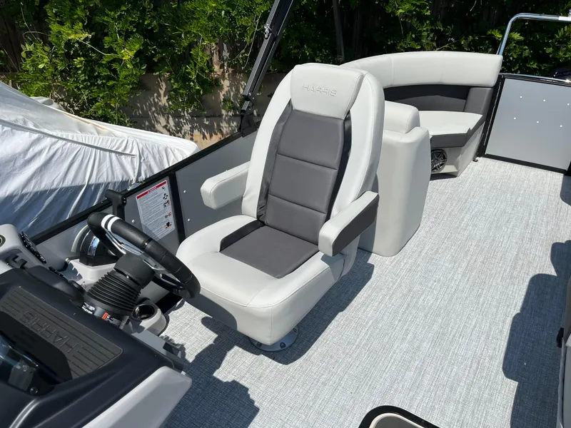 Slide: The Image of 2025 Harris Cruiser 210 boat interior with modern seating and steering console. - 13