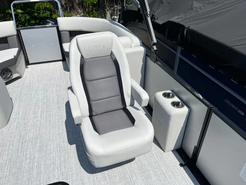Slide: The Image of 2025 Harris Cruiser 210 boat interior with plush seating and cup holders. - 15