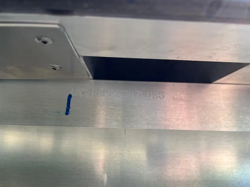 Slide: The Image of Close-up of a metal surface with engraved markings on a 2025 Harris Cruiser 210. - 20