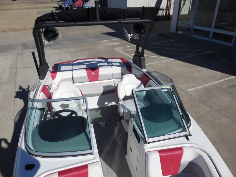 Slide: The Image of 2019 Chaparral 21 H2O Surf boat with red and white interior, open cockpit view. - 11