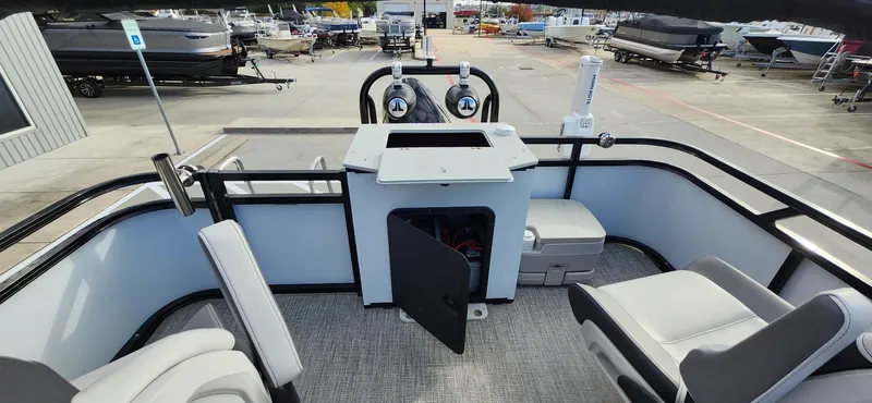 Slide: The Image of 2023 Avalon VEN 2180 FNC boat interior with seating and storage, docked at a marina. - 25